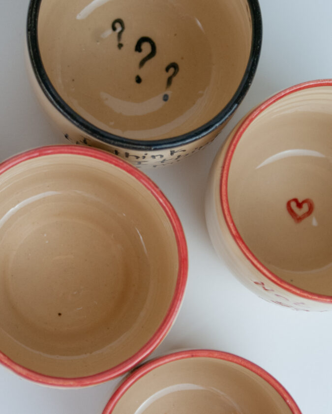 kompozycja z ceramicznych kubków z napisami